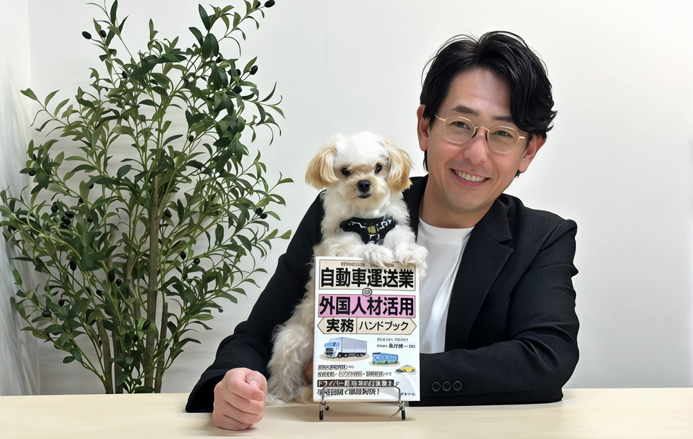 行政書士の長井博一と子犬。その前には自動車運送業分野の外国人材活用実務ハンドブック（日本法令）の書籍